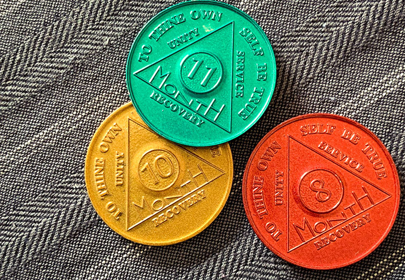 yellow, green and red coins with month numbers on them symbolizing recovery